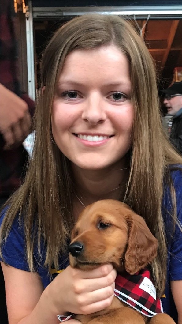 girl smiling holding a puppy