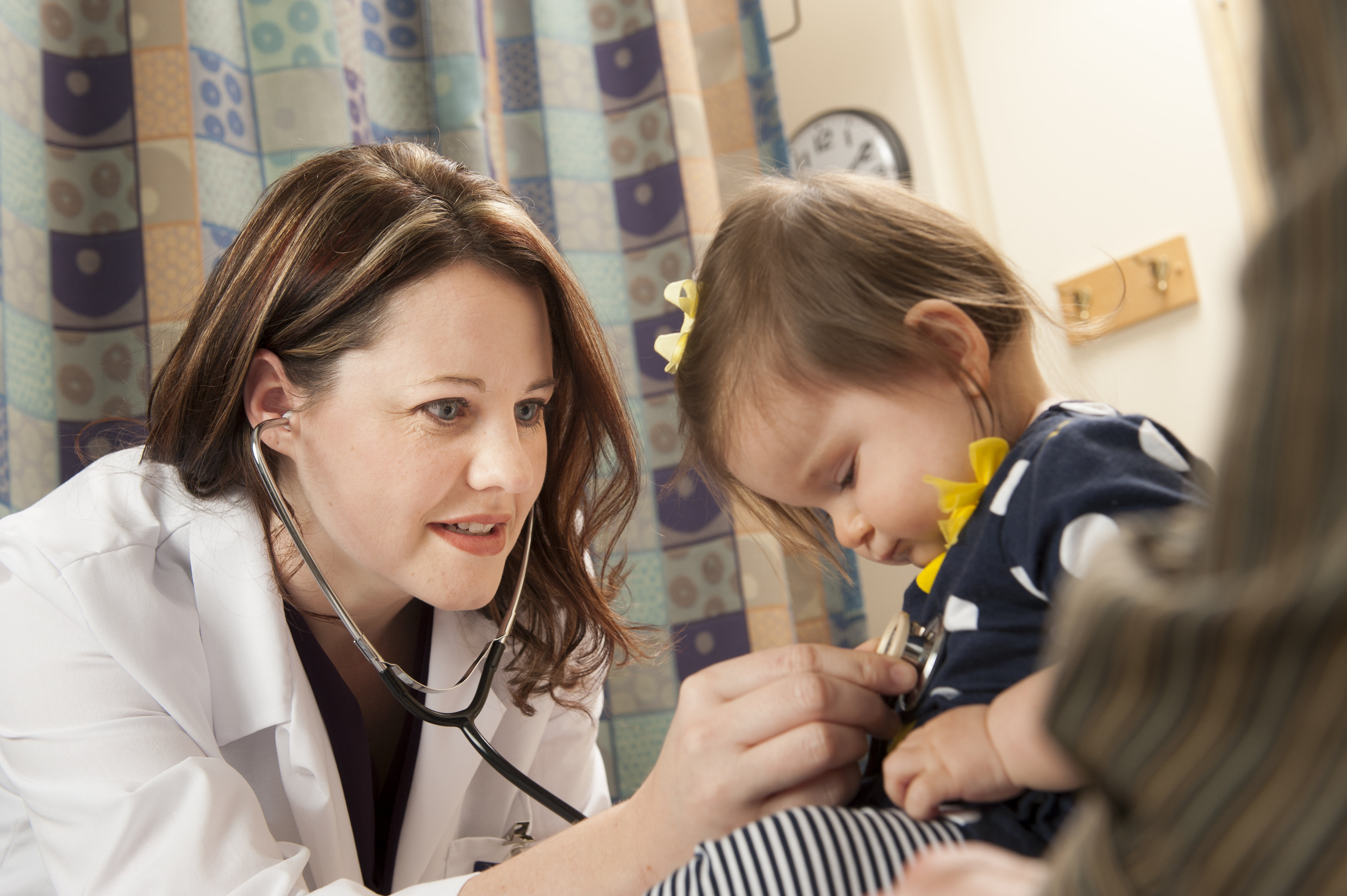 DNP-FNP student holding stethoscope to child