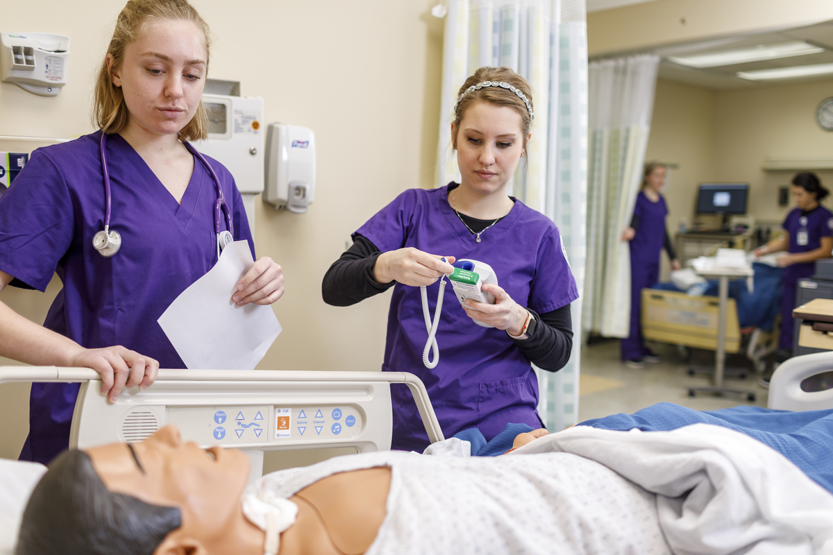Two nursing students in simulation lab with manikin
