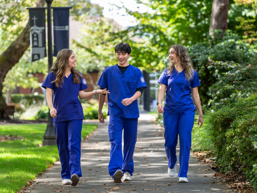 Nursing students in scrubs walking on campus