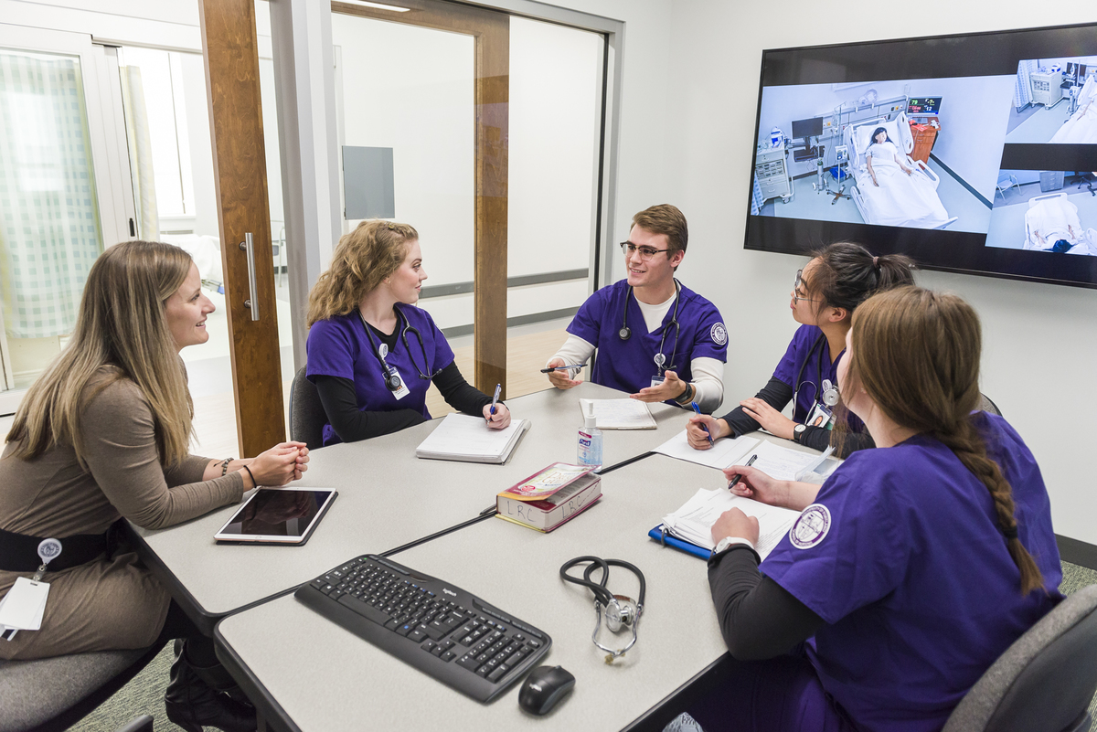 Students with a professor in the simulated health center